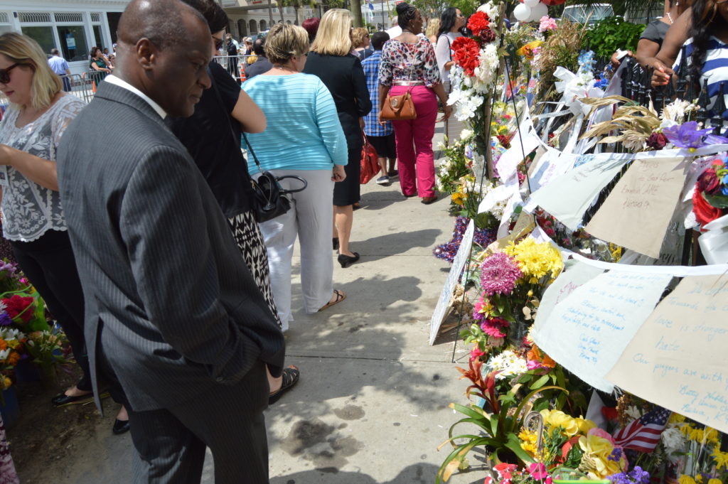 The Rev. Canon John Thompson-Quartey views memorials in front of Emanuel AME Church on the day he delivered the donation from the Episcopal Diocese of Atlanta. Photo: Don Plummer