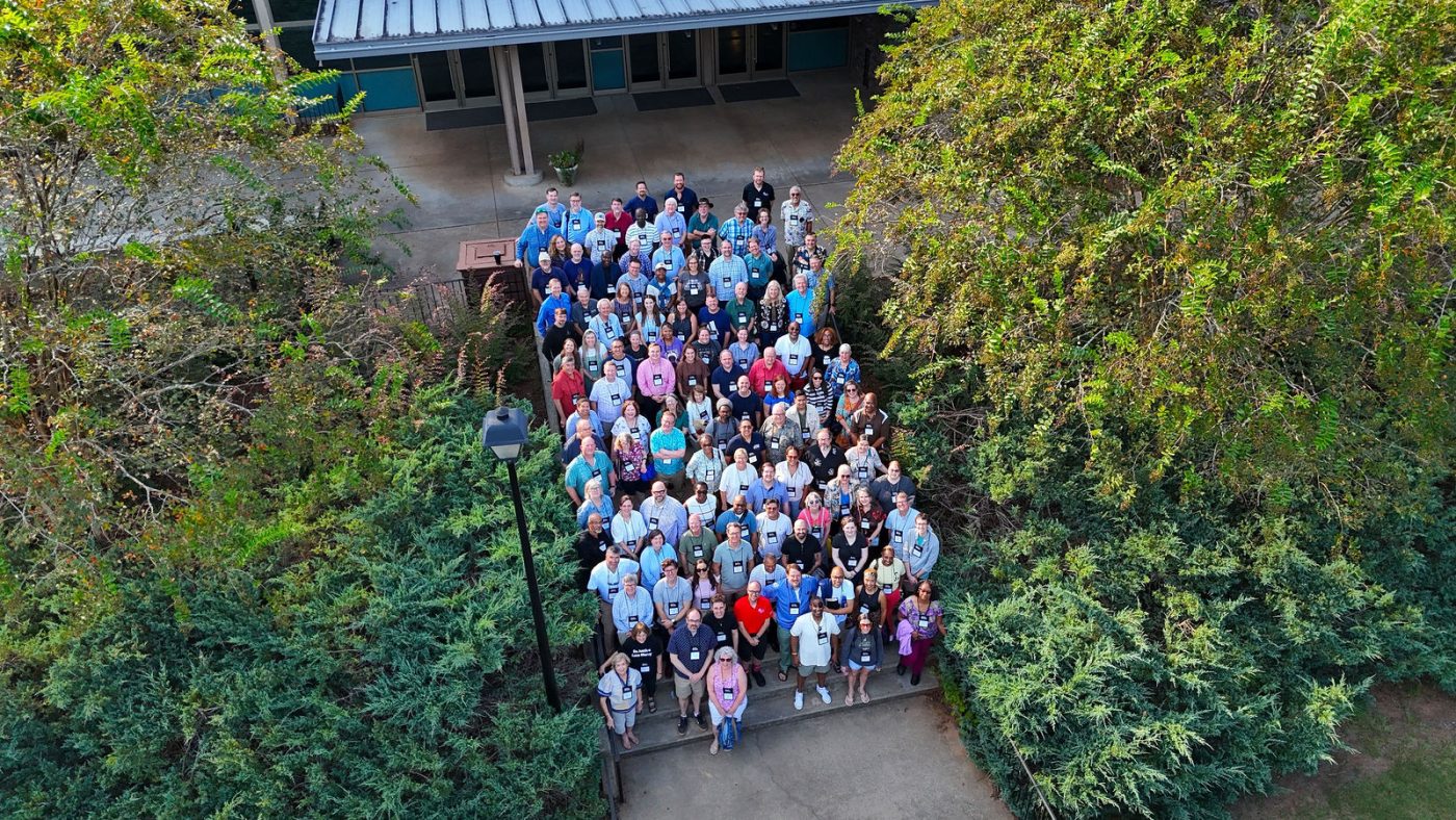 Clergy gather for a group photograph on outdoor steps at Rock Eagle.